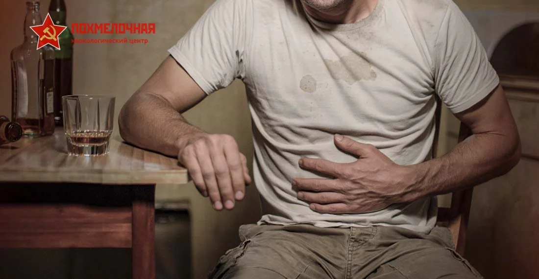 Пьяный мужчина держится за живот от боли